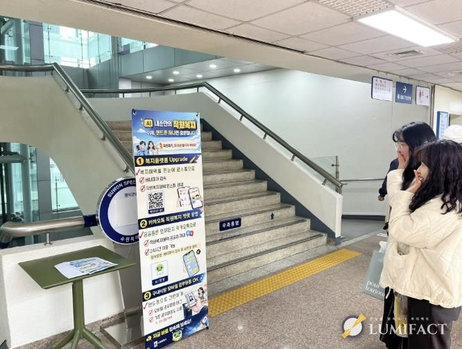 수원시 공직자들이 직원복지통합플랫폼, 인공지능 챗봇 등을 안내하는 홍보물을 보고 있다.